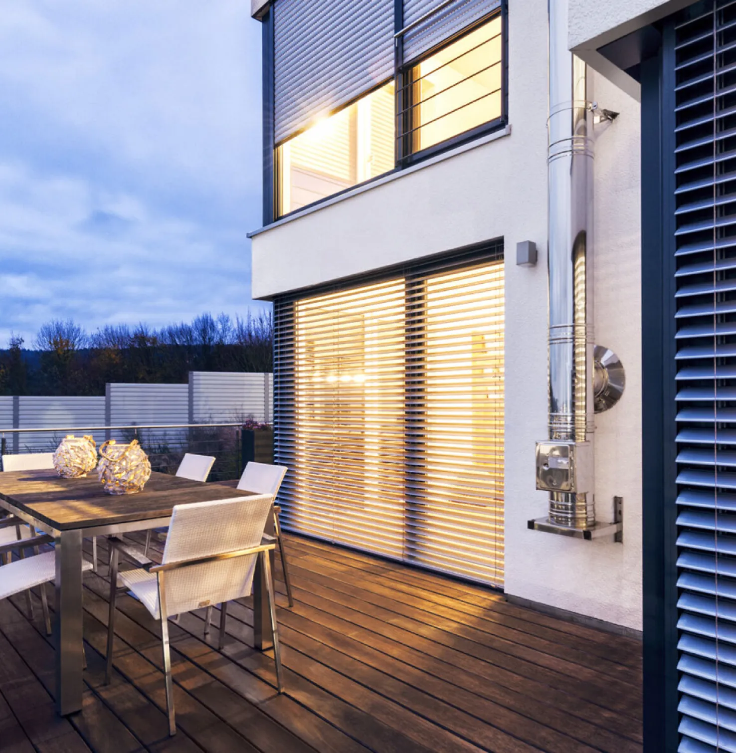 Huis met terras 's avonds binnen helder verlicht met Inbouw buitenjaloezieën